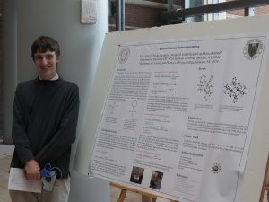 student in front of his poster.