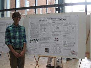 student in front of his poster.